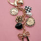 BOW CHECKER HEART FLOWER BAG CHARM | 80K049: Gold
